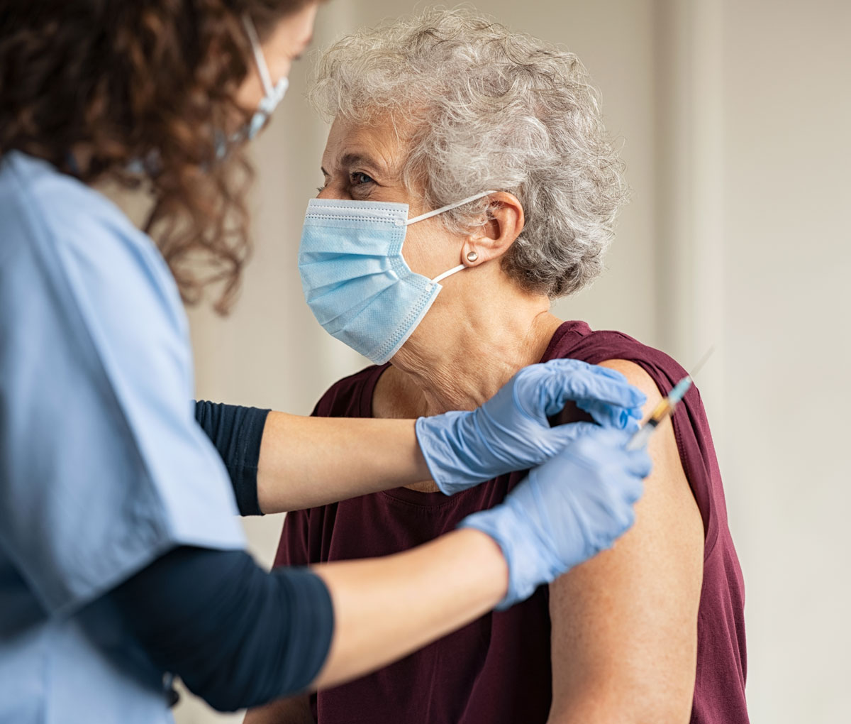 senior woman getting a vaccine from a healthcare worker