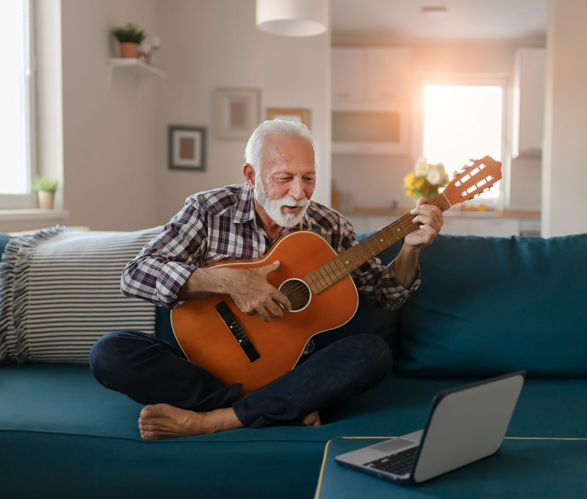 senior man learning to play guitar on youtube