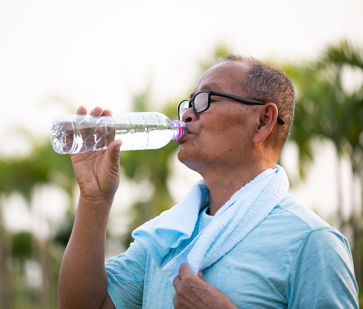 senior man on a walk drinking bottled water