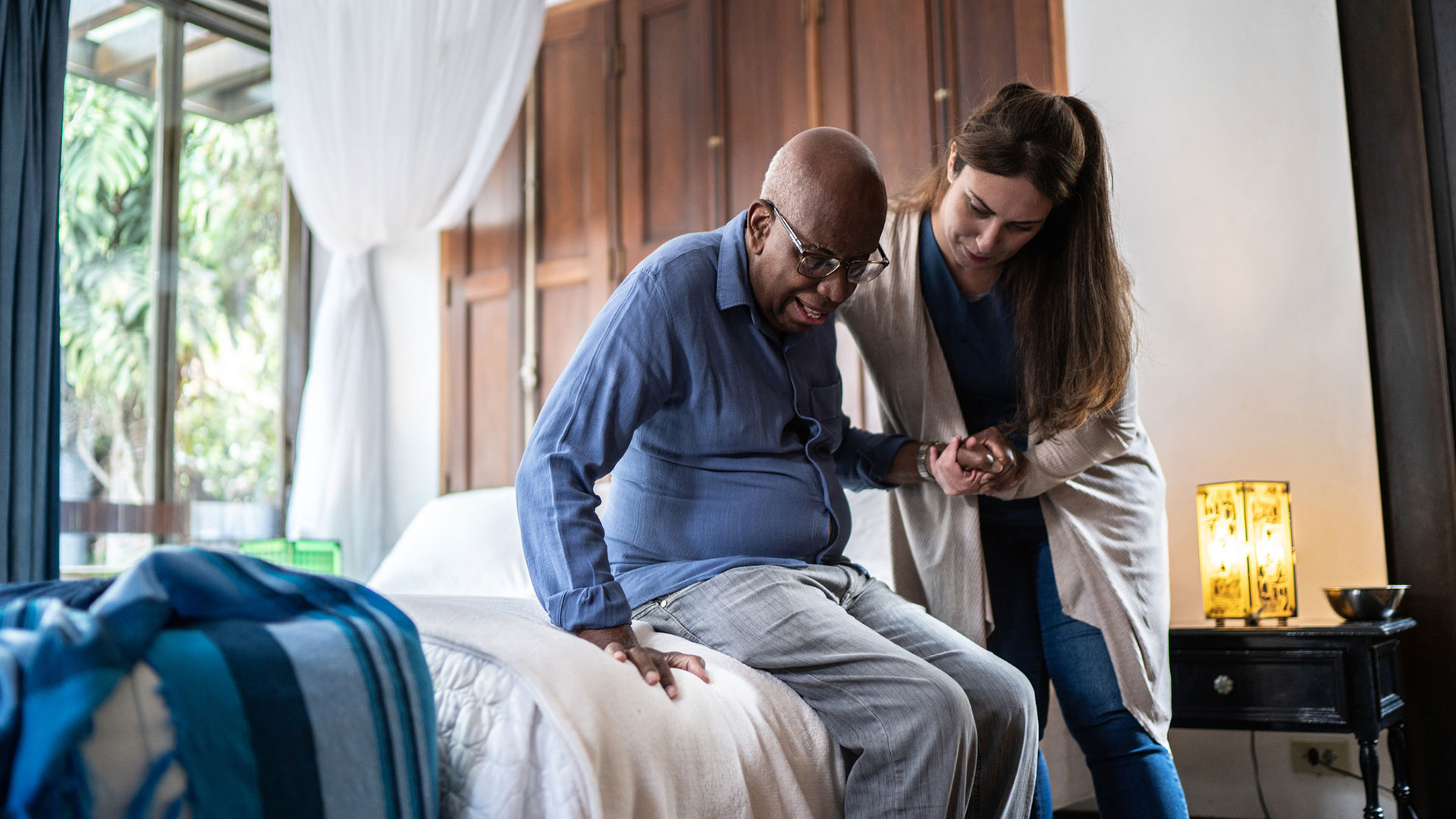 senior man being assisted by his caregiver at a rehabilitation facility