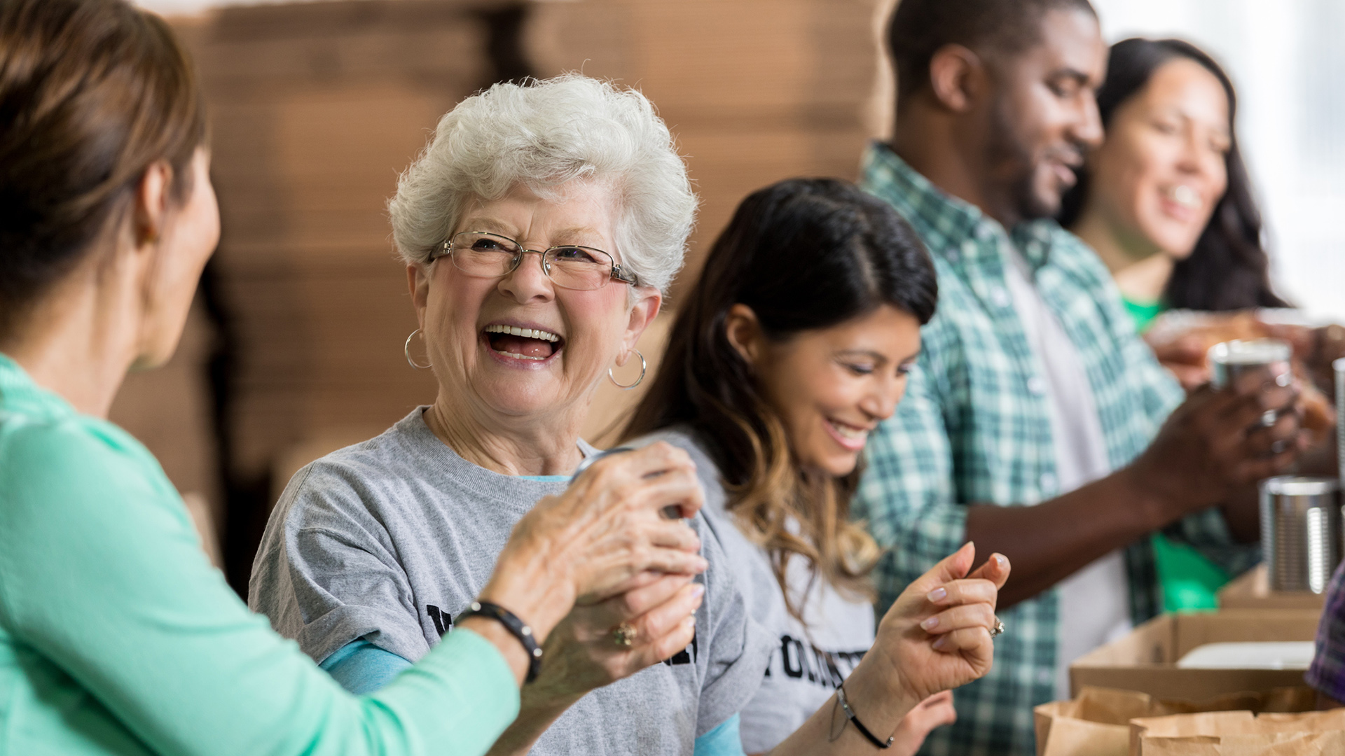 Beautiful cheerful senior woman volunteers at food bank