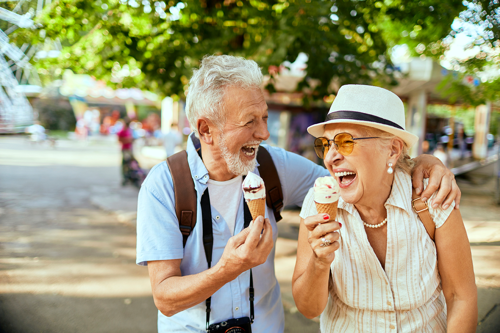senior couple eating ice cream and laughing outside