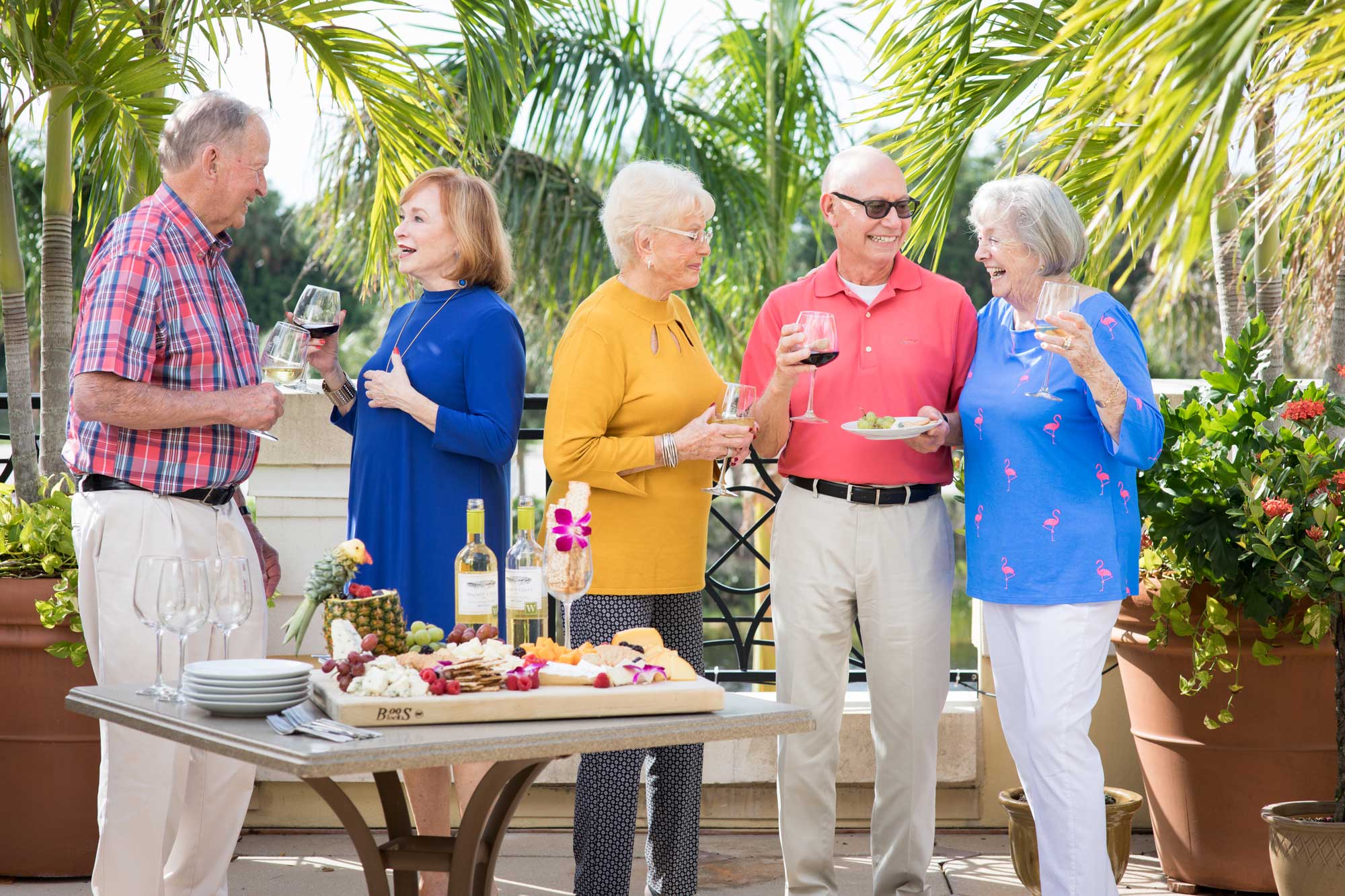a group of seniors enjoying cheese and wine outside at the Terrace at Bonita Springs